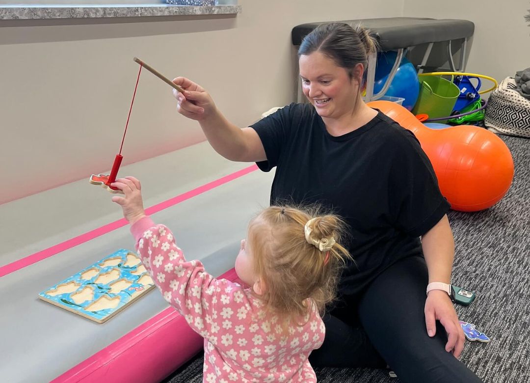 Strengths in Motion - Speech & Occupational Therapy - Occupational Therapy Hero Image Occupational Therapist working with a kid and playing with magnetic fish