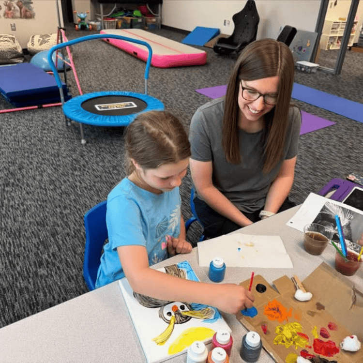 Speech Therapist and child learning while painting Speech Therapist and child learning while painting